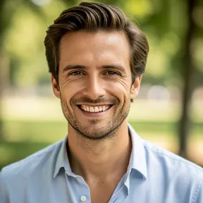 Portrait photo of a French man in his early 30s, friendly smile, outdoors background with soft greenery, natural light, realistic photography, shallow depth of field